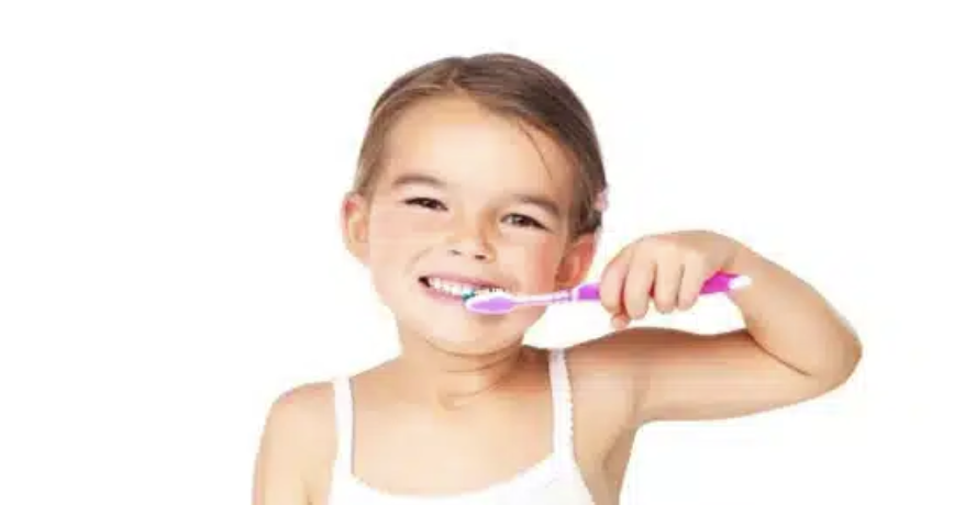 Niña lavándose los dientes gracias al tratamietno de odontopediatría en Madrid